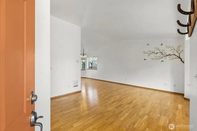 a view of empty room with window and wooden floor