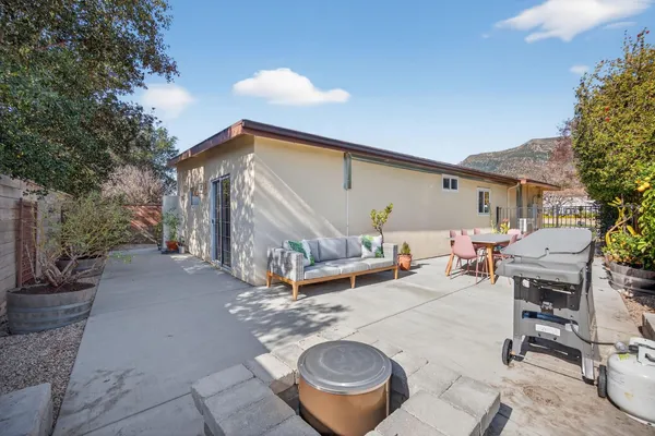 a backyard of a house with barbeque oven table and chairs