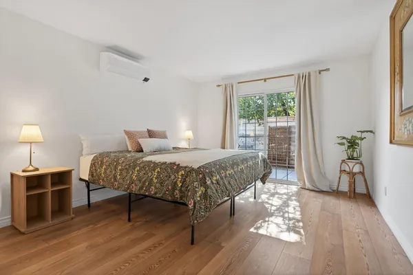 a bedroom with a bed a lamp and a large window