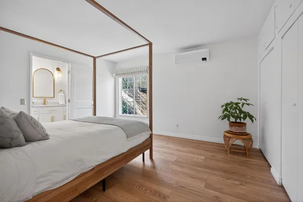 a bedroom with a bed and a potted plant
