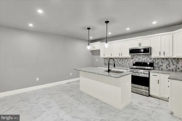 a kitchen with stainless steel appliances granite countertop a sink and microwave