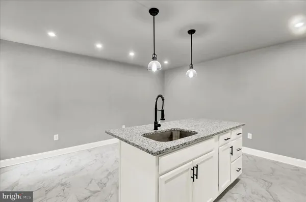 a kitchen with kitchen island granite countertop a sink and chandelier