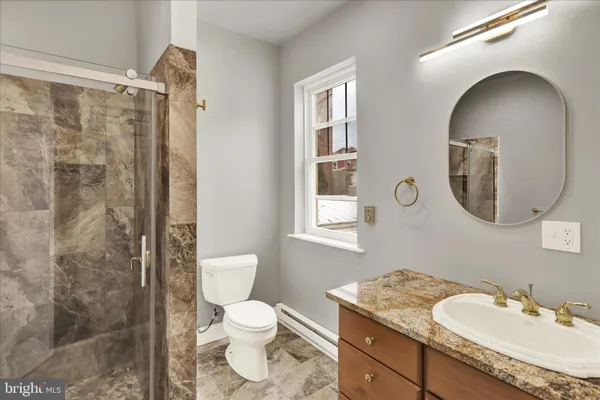 a bathroom with a granite countertop sink toilet and shower