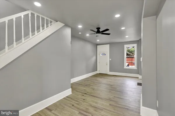 a view of an empty room with window and wooden floor
