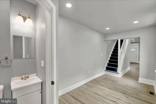 a view of a hallway with wooden floor and staircase