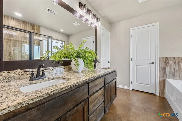 a bathroom with a granite countertop sink a large mirror and a shower