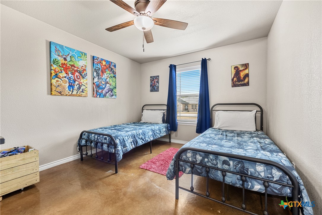 7112 Kc Ranch Court Temple, TX 76501 - Photo 22 of 30 a bedroom with a bed and a chandelier