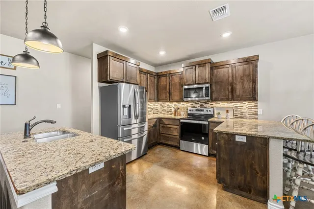 a kitchen with granite countertop stainless steel appliances and wooden cabinets