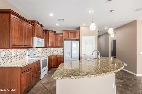 a kitchen with stainless steel appliances granite countertop a sink a refrigerator and a stove