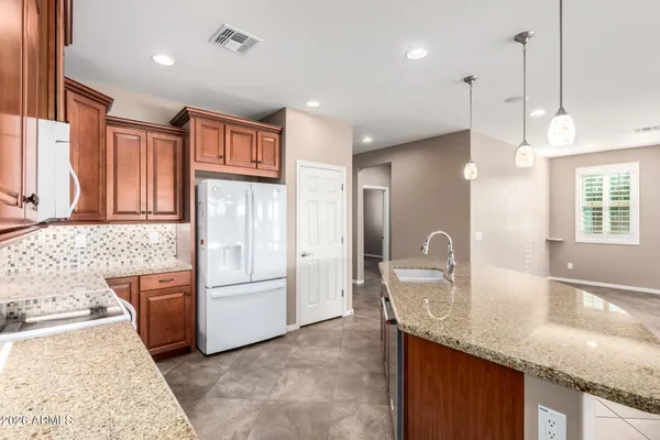 a kitchen with granite countertop a sink and a refrigerator