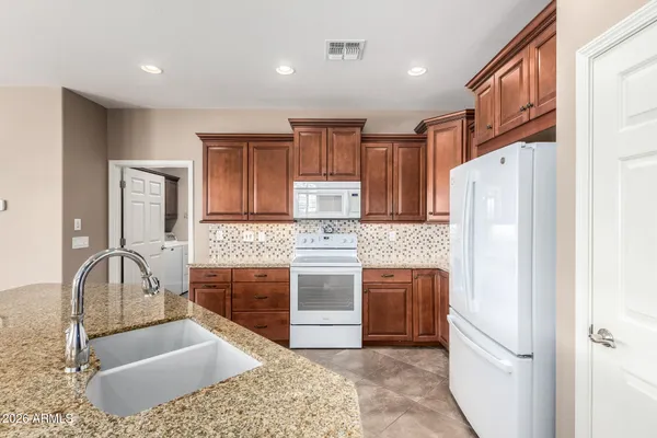 a kitchen with stainless steel appliances granite countertop a refrigerator and a stove