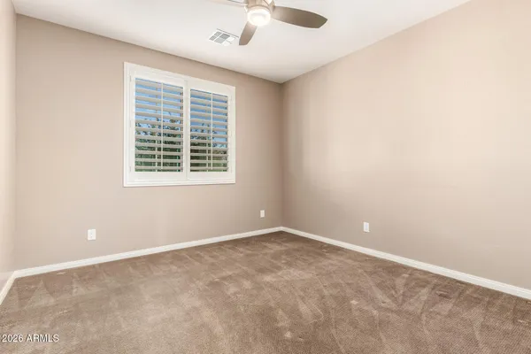 an empty room with a window and a fan