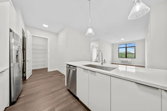 a kitchen with a sink and wooden floor