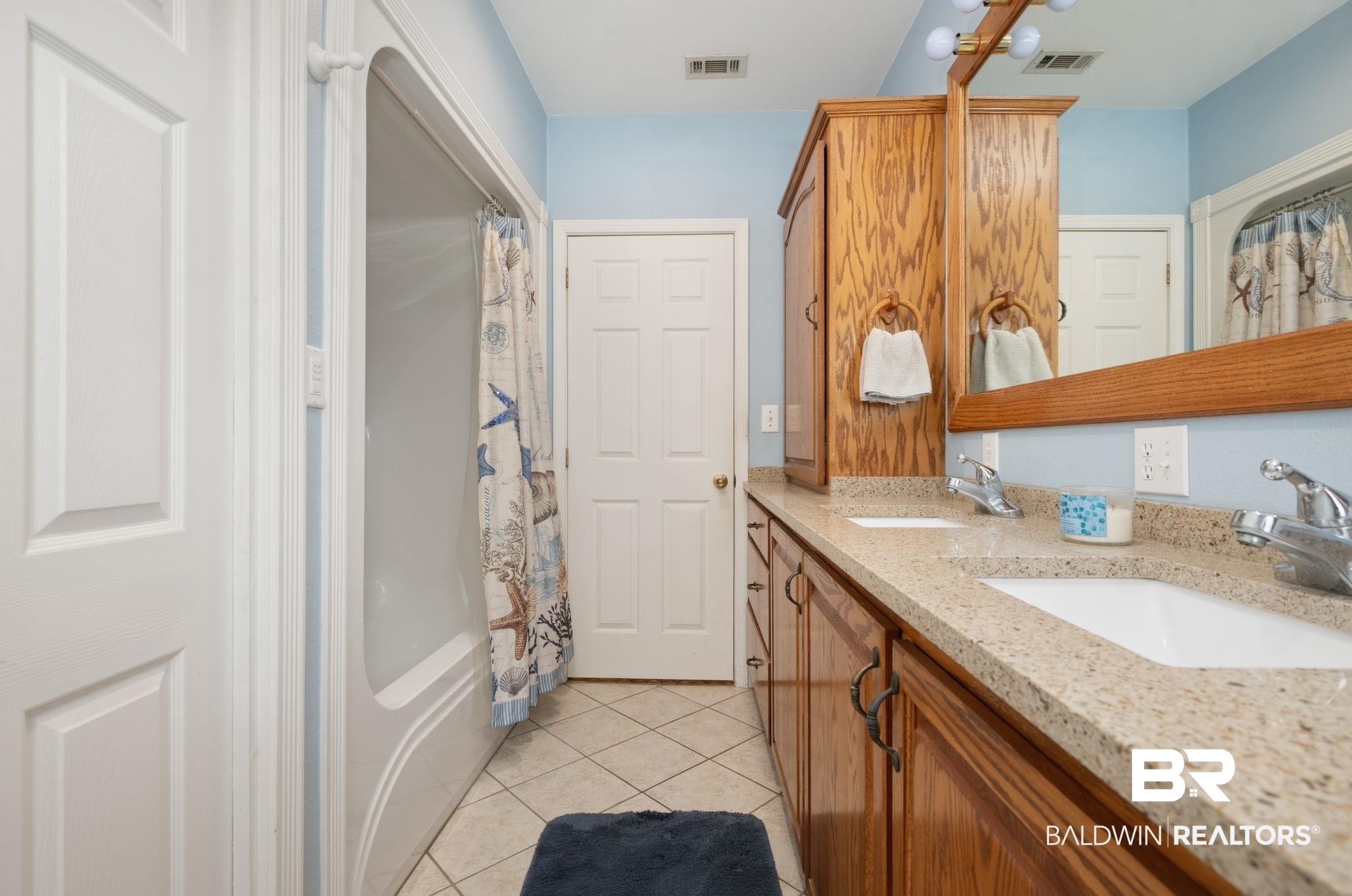 15025 Bellingrath Road Coden, AL 36523 - Photo 49 of 79 Full bath with double vanity, light tile patterned floors, and shower / bathtub combination with curtain
