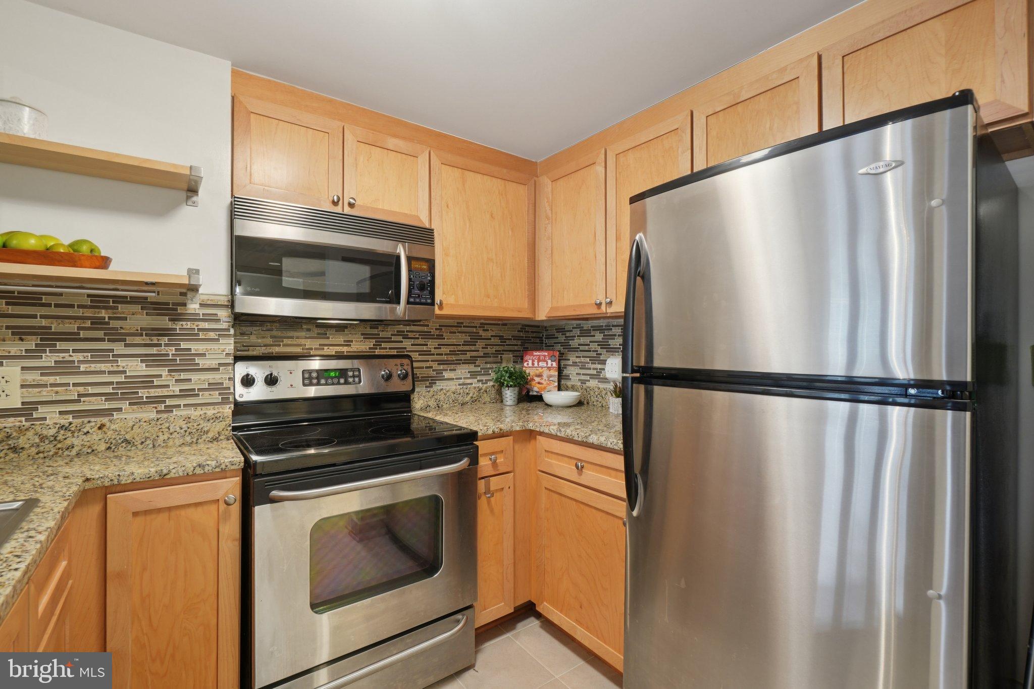 1150 K Street Northwest, Unit 1111 Washington, DC 20005 - Photo 6 of 36 a kitchen with stainless steel appliances a refrigerator stove and microwave