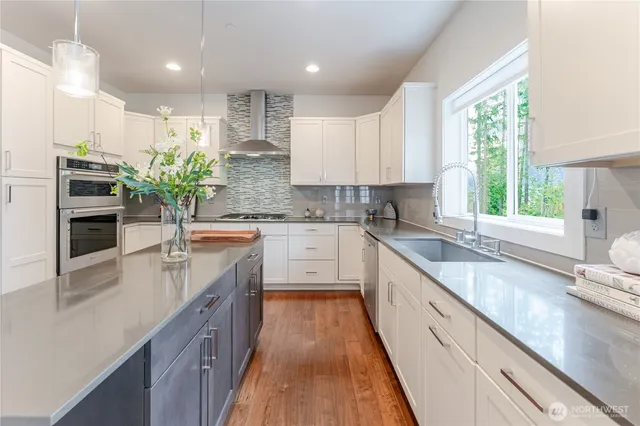 a kitchen with kitchen island granite countertop a sink a counter top space and living room area