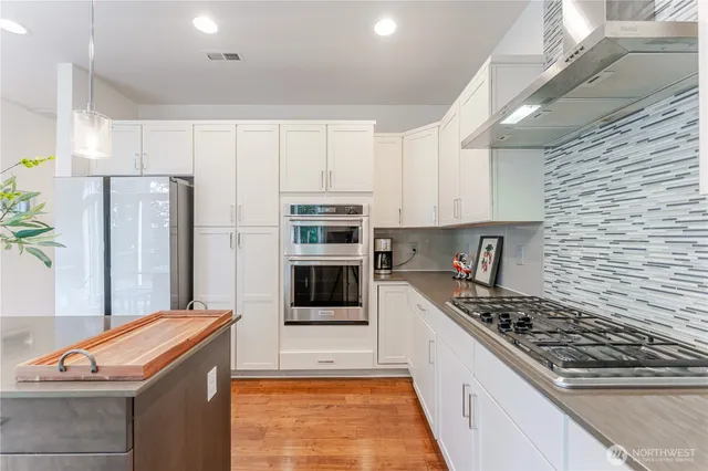 a kitchen with kitchen island granite countertop a sink cabinets and wooden floor