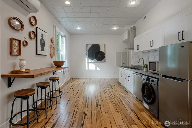 a living room with furniture and a view of kitchen