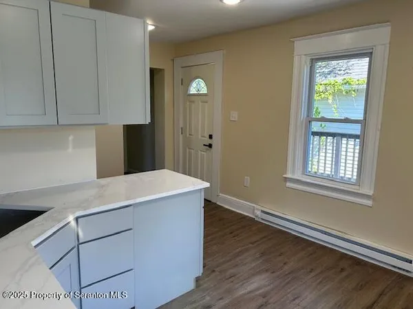 a room with a wooden floor and cabinets