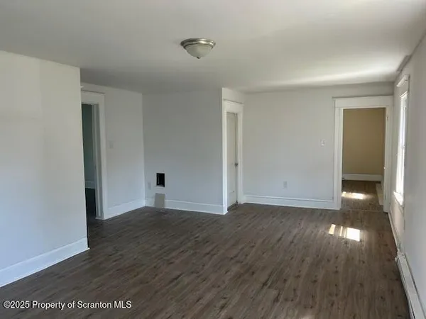 a view of an empty room with wooden floor