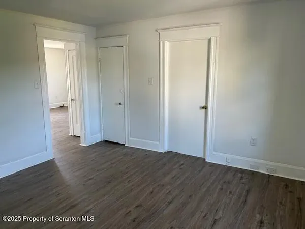an empty room with wooden floor and closet