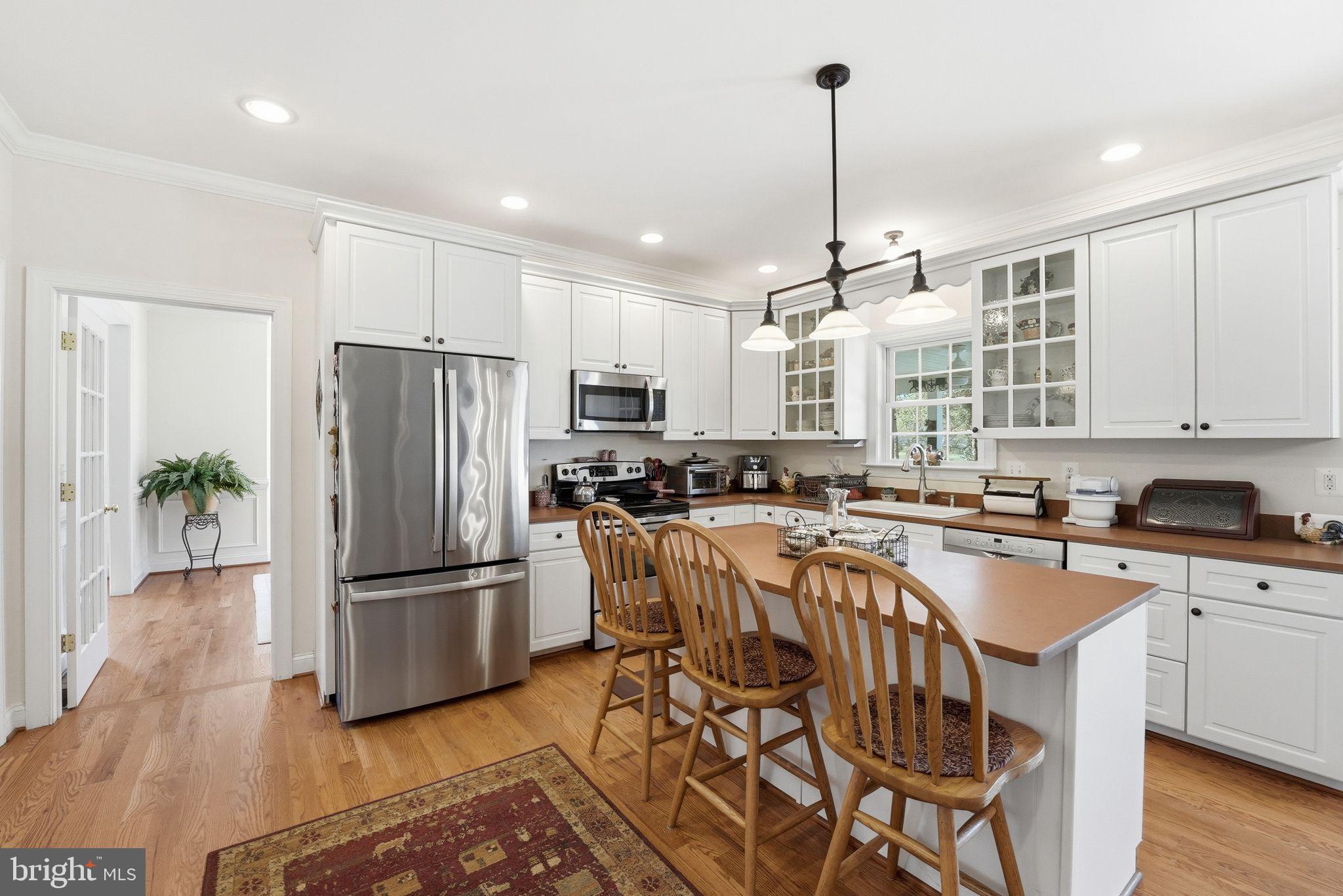 140 Woods Ridge Lane Reva, VA 22735 - Photo 8 of 87 a kitchen with stainless steel appliances granite countertop a refrigerator a sink dishwasher a stove and white cabinets with wooden floor