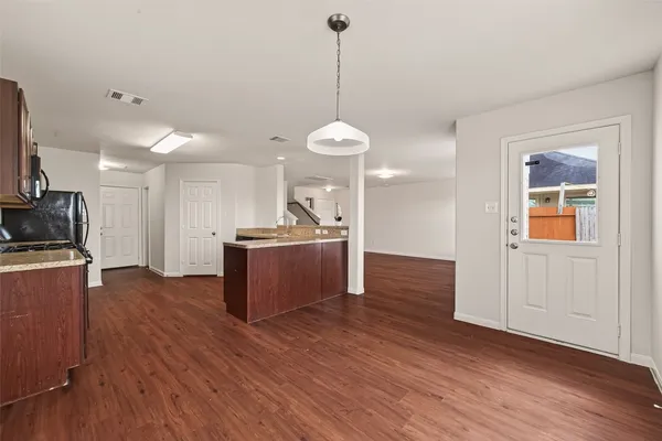 a kitchen with stainless steel appliances granite countertop cabinets a wooden floor and a sink