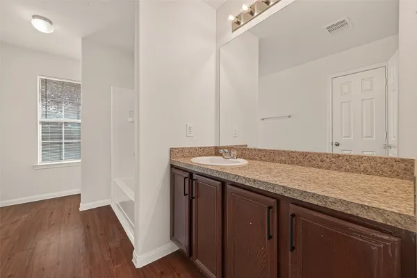 a bathroom with a granite countertop sink and a mirror
