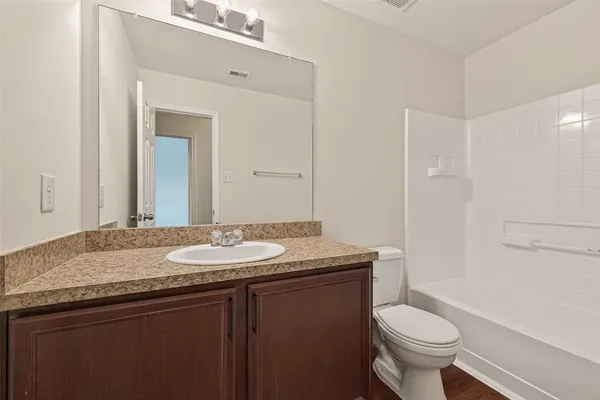 a bathroom with a granite countertop sink a toilet and a mirror
