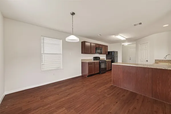 a view of a kitchen with a sink wooden floor oven and a window