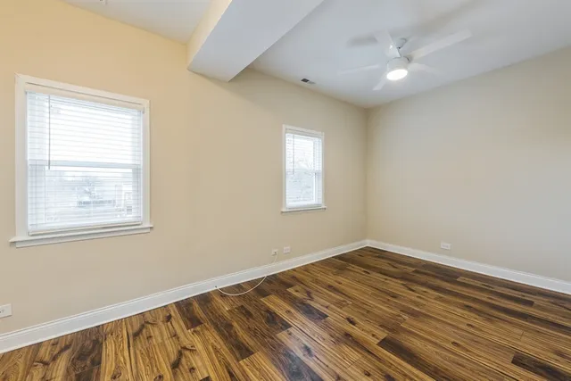 a view of a room with wooden floor and a window