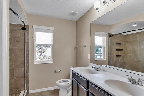 a bathroom with a granite countertop sink toilet and shower