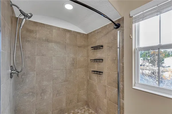 a bathroom with a shower and a glass shower door