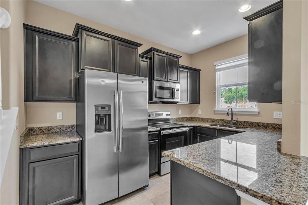 106 Carmichael Way Daytona Beach, FL 32124 - Photo 7 of 35 a kitchen with stainless steel appliances granite countertop a sink stove and refrigerator