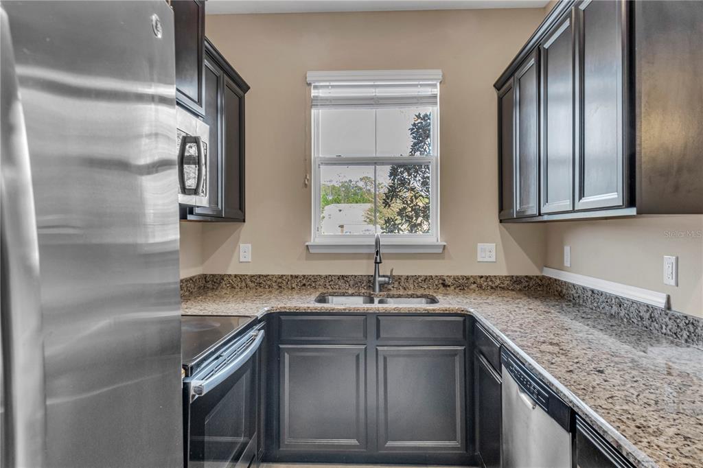 106 Carmichael Way Daytona Beach, FL 32124 - Photo 8 of 35 a kitchen with stainless steel appliances granite countertop a sink stove and cabinets