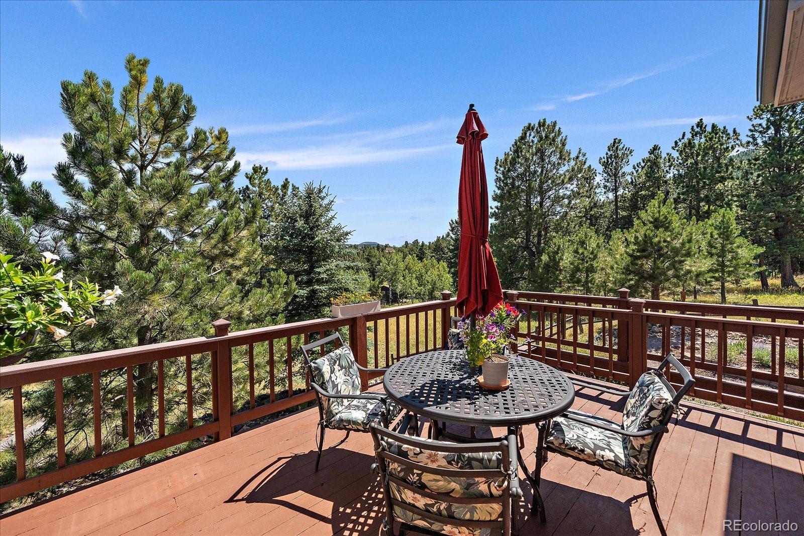 31518 Niakwa Road Evergreen, CO 80439 - Photo 14 of 48 a view of a chairs and table on the deck