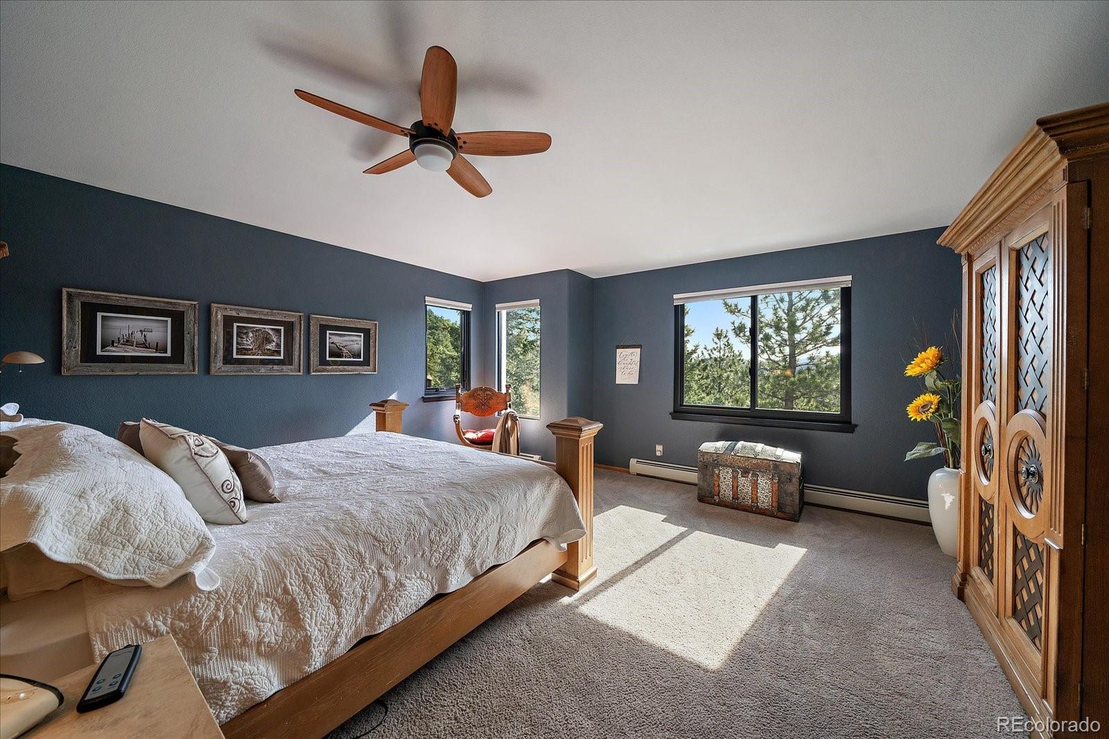 31518 Niakwa Road Evergreen, CO 80439 - Photo 18 of 48 a bedroom with a bed and a chandelier