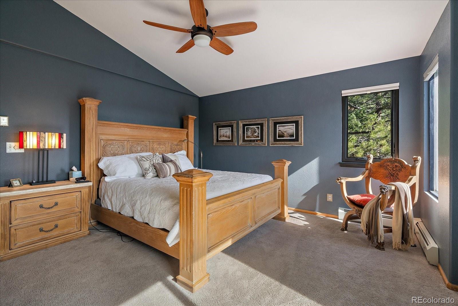 31518 Niakwa Road Evergreen, CO 80439 - Photo 19 of 48 a bedroom with a bed and a chandelier