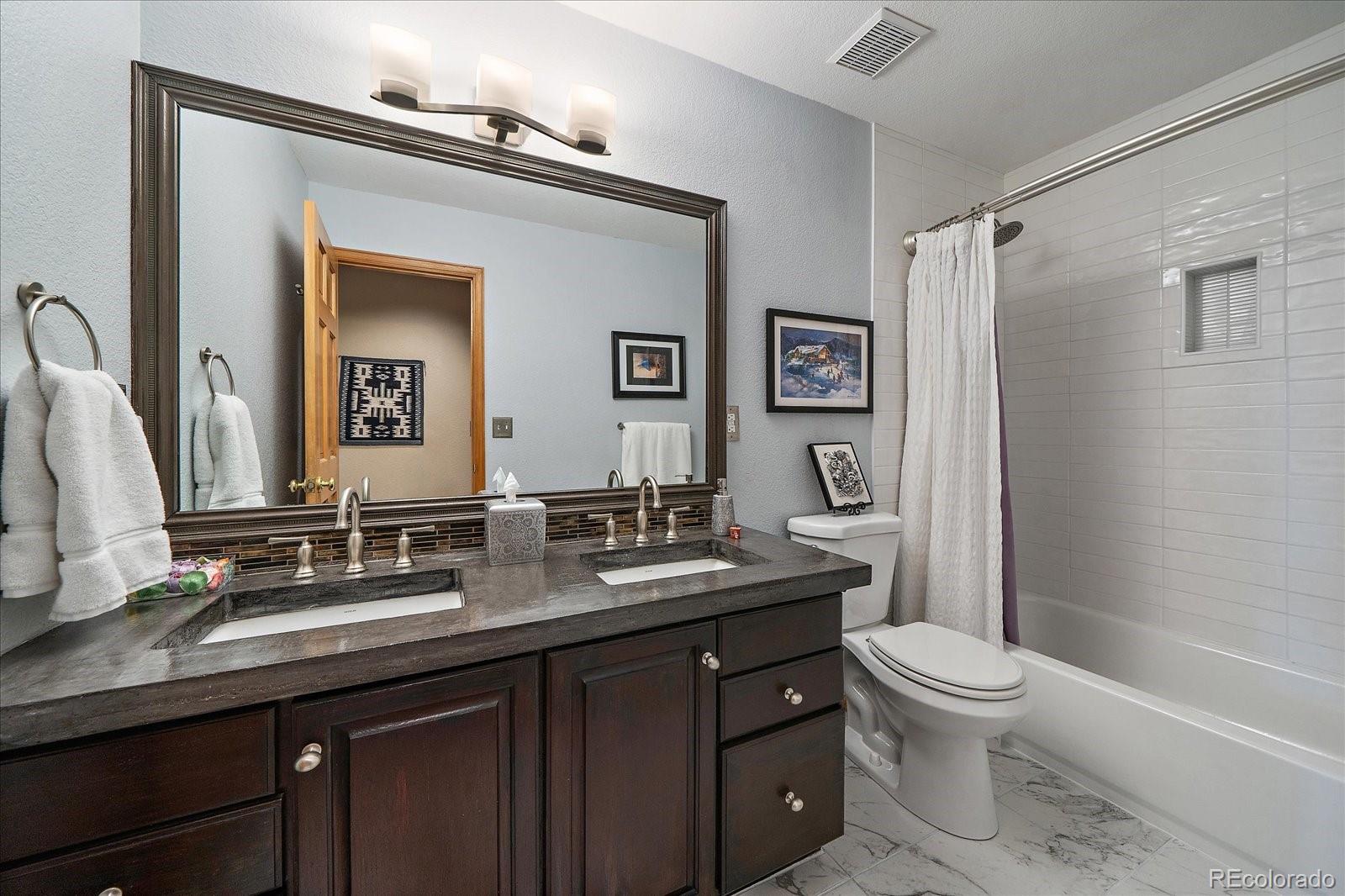 31518 Niakwa Road Evergreen, CO 80439 - Photo 24 of 48 a bathroom with a granite countertop toilet sink and mirror