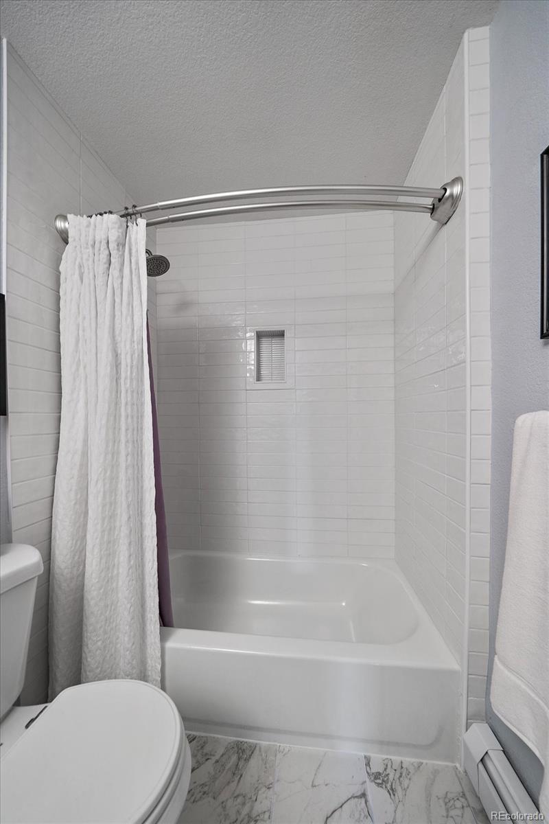 31518 Niakwa Road Evergreen, CO 80439 - Photo 25 of 48 a bathroom with a shower curtain and a toilet