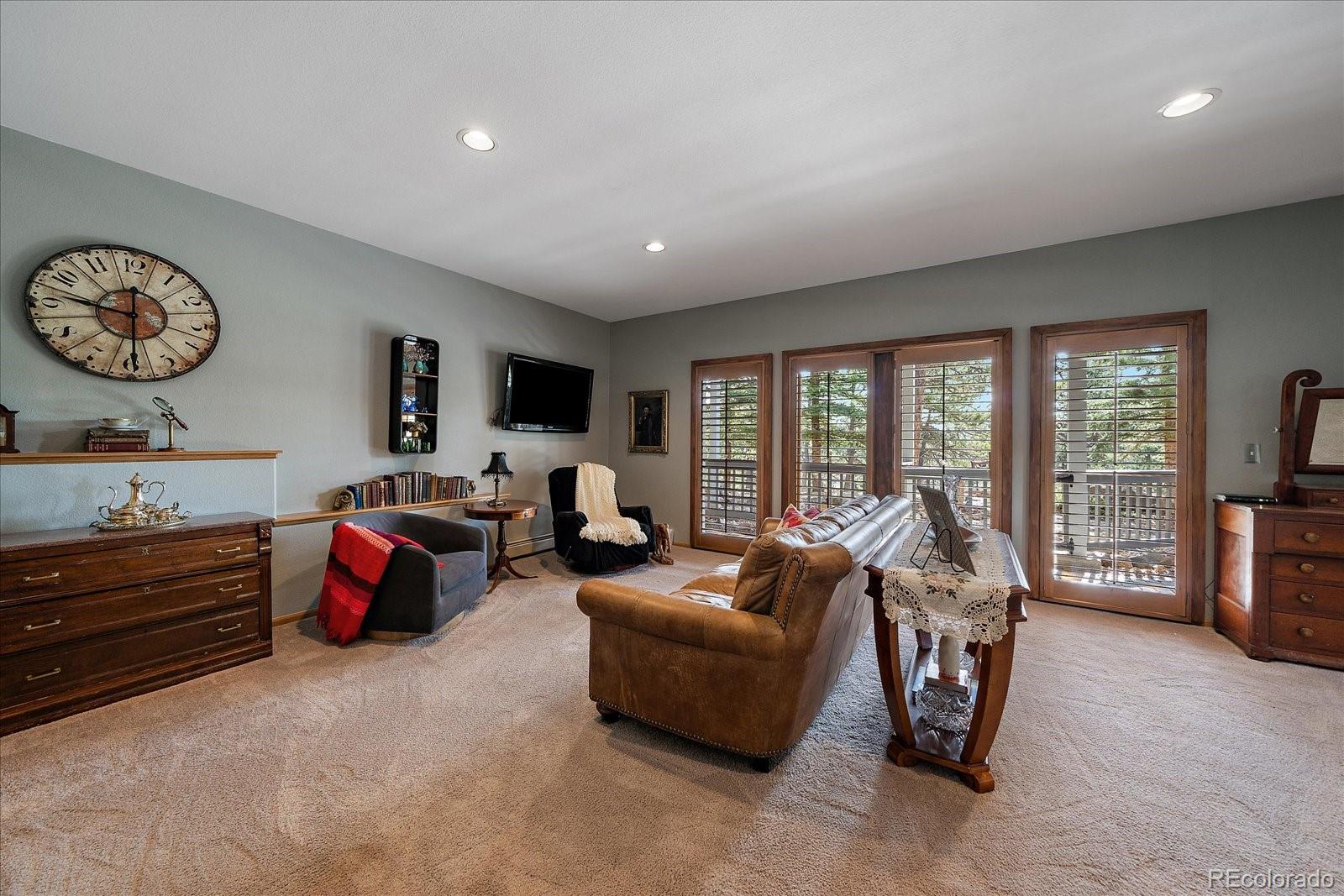 31518 Niakwa Road Evergreen, CO 80439 - Photo 27 of 48 a living room with furniture a flat screen tv and a large window
