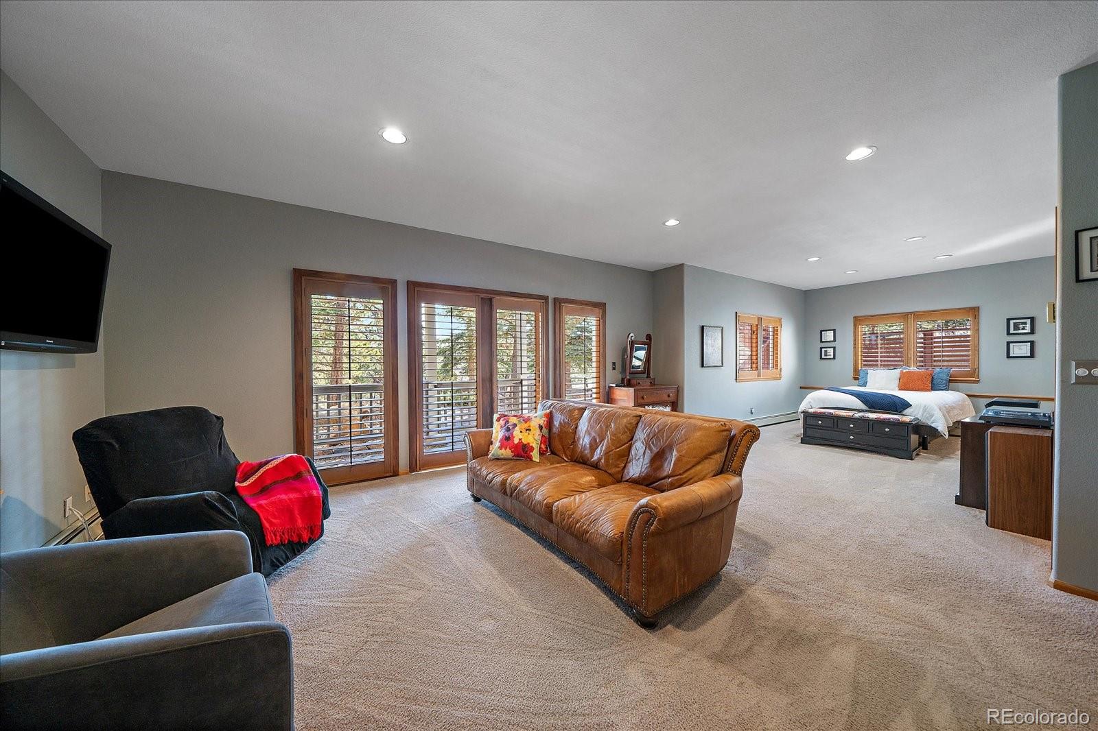 31518 Niakwa Road Evergreen, CO 80439 - Photo 28 of 48 a living room with furniture ceiling fan and a flat screen tv