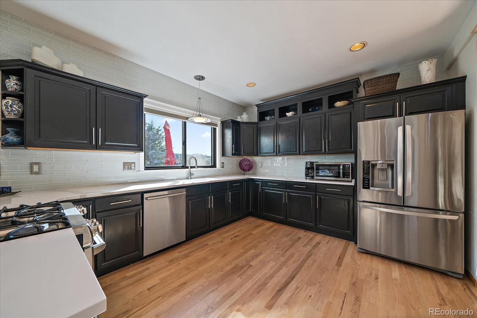 31518 Niakwa Road Evergreen, CO 80439 - Photo 4 of 48 a kitchen with granite countertop a refrigerator stove top oven and sink