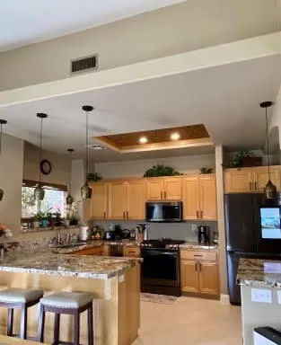 a kitchen with stainless steel appliances granite countertop a stove a sink and a refrigerator