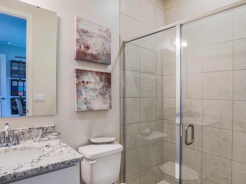 4021 Maggie Loop Lakeland, FL 33813 - Photo 20 of 29 a bathroom with a granite countertop toilet a sink and shower