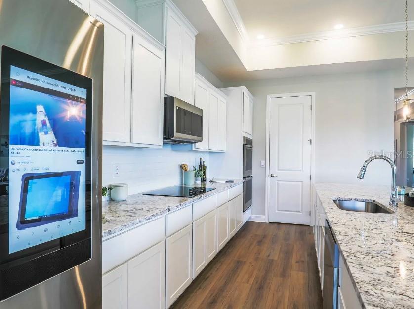 4021 Maggie Loop Lakeland, FL 33813 - Photo 7 of 29 a kitchen with granite countertop a stove top oven a sink dishwasher and wooden floor