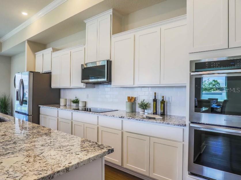 4021 Maggie Loop Lakeland, FL 33813 - Photo 8 of 29 a kitchen with stainless steel appliances granite countertop a stove a sink a microwave a refrigerator and cabinets