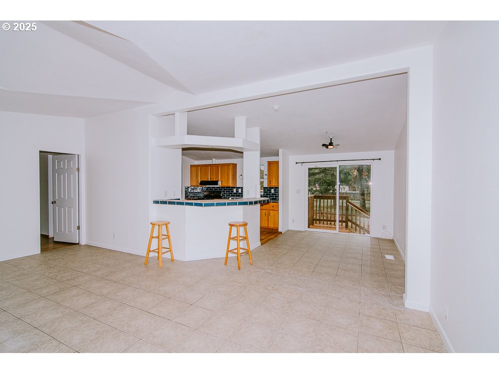 88247 Ellmaker Road Veneta, OR 97487 - Photo 15 of 47 a view of an empty room with a window and a kitchen