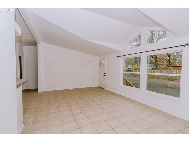 a living room with stainless steel appliances kitchen island granite countertop furniture a rug and a window