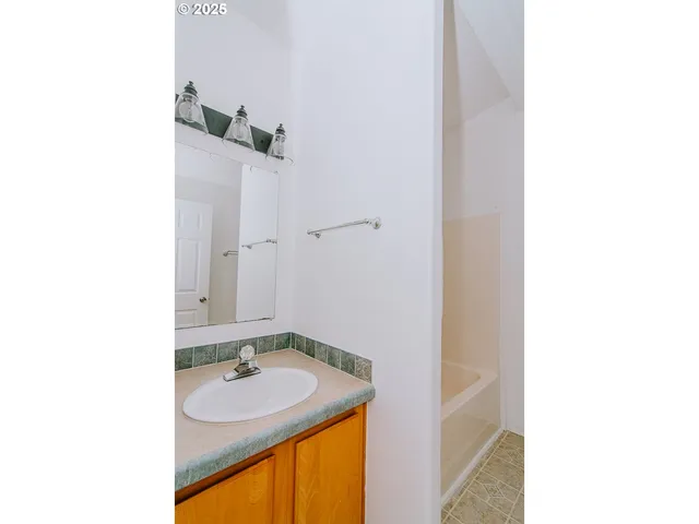 a view of empty room with wooden floor and window